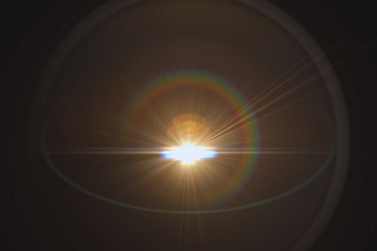A stunning abstract lens flare featuring a vibrant rainbow-colored circular ring. The central light source radiates sharp beams against a dark background, creating a cinematic and artistic lighting ef