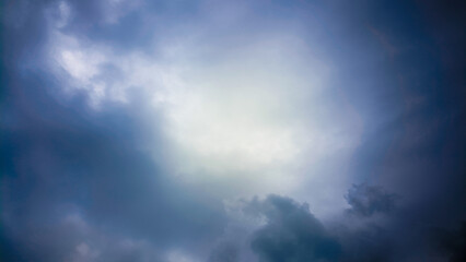 Obraz premium Dramatic and moody sky with dark storm clouds gathering and a bright patch of light breaking through, suggesting hope or a change in weather
