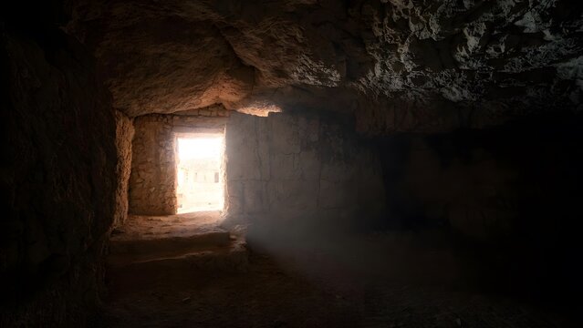 The image depicts Christ calling Lazarus out of the tomb from the dead as the main subject as light penetrates deeper into the cave space + stone interior walls revealed gradually by advancing illumin