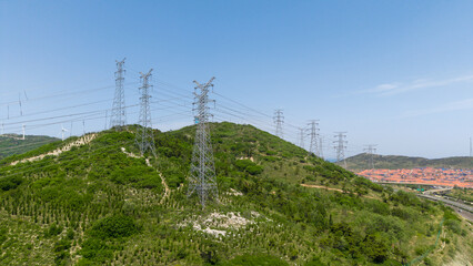 Obraz premium High-Voltage Power Transmission Towers on Green Hills
