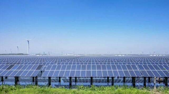 Time-lapse of Floating Solar Panels and Wind Turbines on Coastal Wetland Under Clear Blue Sky  