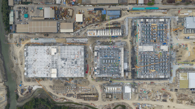 Tambon Khlong Tamru, Thailand - 11 March 2026: Aerial view of a large industrial construction site with multiple buildings under development, cranes, and heavy machinery.
