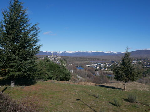 Panoramic view of Puebla de Sanabria and the snow-covered mountains of the Sierra de la Culebra under a clear blue sky in Castilla y Le&oacute;n, Spain.