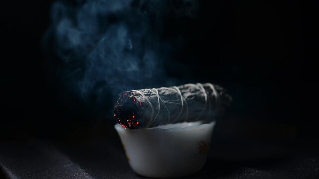 Sage lighter flame isolated sage flame smoke, dark background studio, ceremony spiritual practice theme, selective focus shadow depth of view 