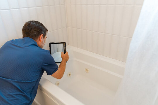 Home inspector inspecting bath tub tiles. Home health inspection. Mold inspection.