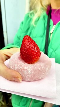  Close-up of a person holding a Japanese strawberry daifuku mochi