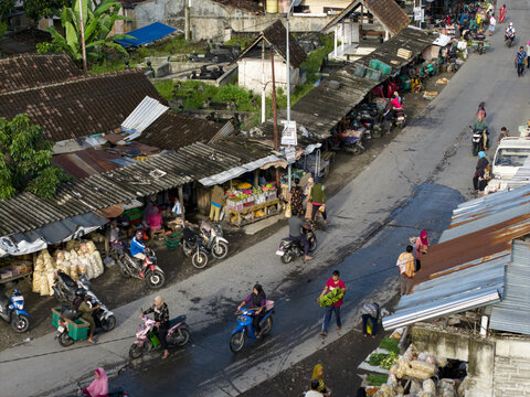 Klaten, Indonesia - 23 April 2026: Aerial view of Pasar Kembang Klaten traditional market with motorbikes on the street, stalls under corrugated roofs, and people shopping in Central Java.