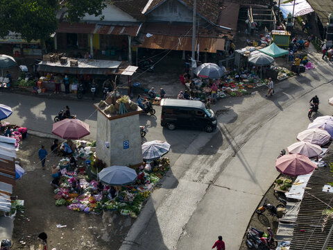 Klaten, Indonesia - 23 April 2026: Aerial view of Pasar Kembang Klaten traditional market with vendors under colorful umbrellas, motorcycles, and a central monument.