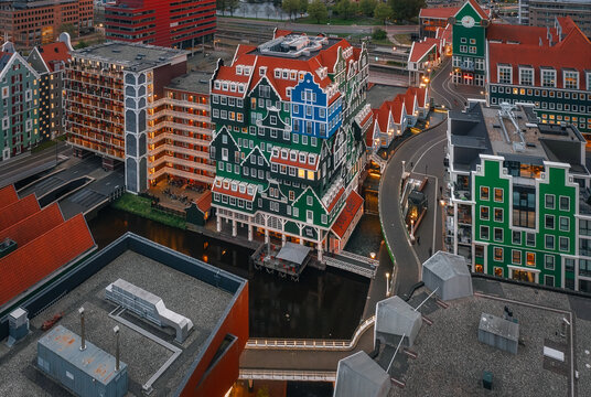 Zaandam, Netherlands - 26 April 2022: Aerial view of Inntel Hotels Amsterdam Zaandam with its unique stacked traditional house facade and surrounding urban canals at dusk.