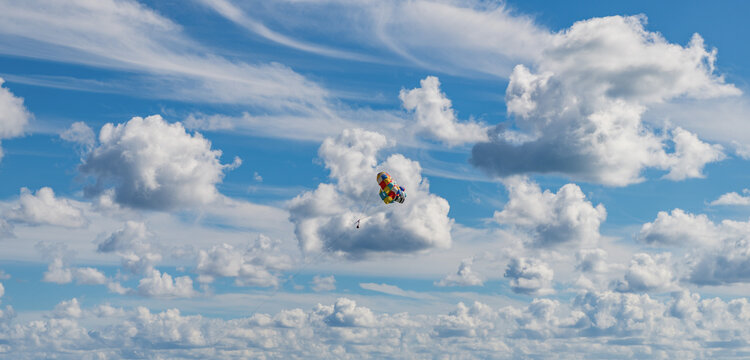 Parasailing sport activity. Parachute in the sky. Extreme rest and parasailing. Summer vacation. Sea sport. Parachute parasail. Water sport on summer vacation. Parasailing recreation with parachute