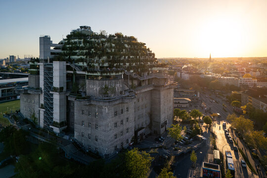 Hamburg, Germany - 01 May 2026: Aerial view of the St. Pauli Bunker featuring its lush rooftop garden and modern concrete architecture under a warm sunset glow.