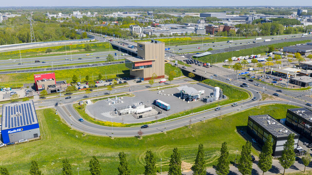 Utrecht, Netherlands - 29 April 2026: Aerial view of the LNG and hydrogen Tankstation Rolande featuring fuel pumps and designated parking spaces next to a busy road with passing vehicles.