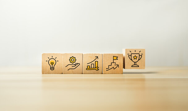 Business development process concept with wooden blocks showing idea, improvement, growth, milestone and achievement with trophy icon representing success, strategy and performance
