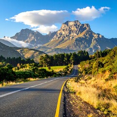 Fototapeta premium A scenic road winding through a lush landscape with a majestic mountain range