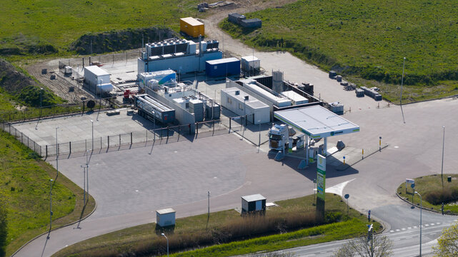 Oude-Tonge, Netherlands - 25 April 2026: Aerial view of the Rolande LNG fueling station with a white truck parked under the canopy and industrial storage units.