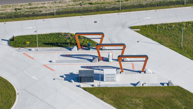 Zwolle, Netherlands - 23 April 2026: Aerial view of Milence Charging Hub Zwolle featuring modern orange charging arches and concrete infrastructure for electric trucks.