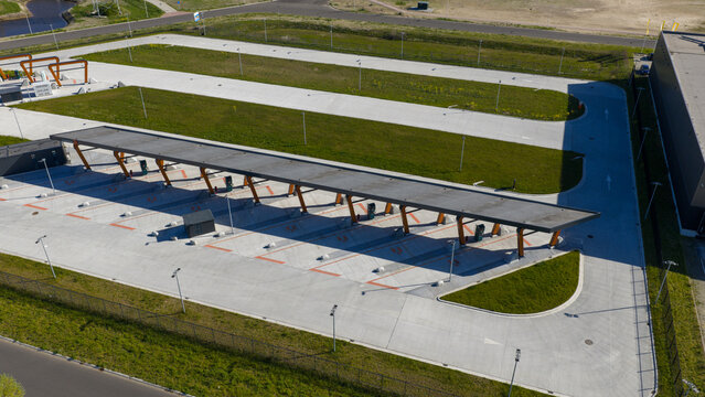 Zwolle, Netherlands - 23 April 2026: Aerial view of Milence Charging Hub Zwolle with its distinctive wooden canopy and concrete parking bays under a clear sky.