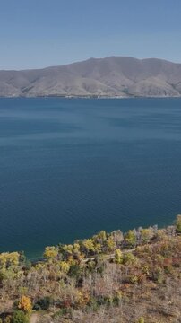 Drone view over Lake Sevan, autumn shoreline and distant hills, Armenia