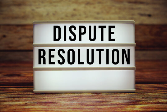 Lightbox with text "Dispute Resolution" on wooden background