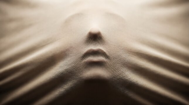 Ethereal conceptual shot of a human face pressing through a thin, beige fabric, creating a haunting silhouette that symbolizes suffocation, hidden identity, and psychological struggle.