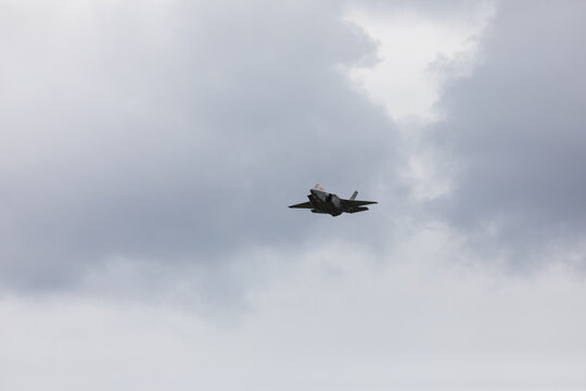 American 5th generation stealth fighter jet of the US Air Force performing aerial maneuvers in cloudy skies. Powerful modern military aircraft flying during aviation demonstration
