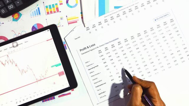 accountant reviewing financial profit and loss statement with digital tablet and market analysis reports for business growth