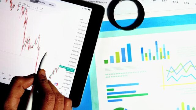 financial analyst using digital tablet to analyze stock market trend charts and corporate business growth reports