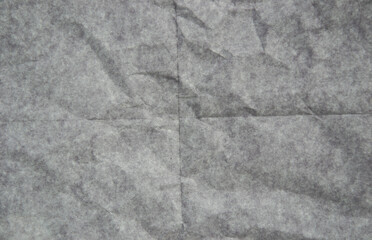 Obraz premium Dark crumpled paper texture with visible fold marks, distressed wrinkles and grunge surface. Abstract paper background with aged dirty texture, creased sheet effect.