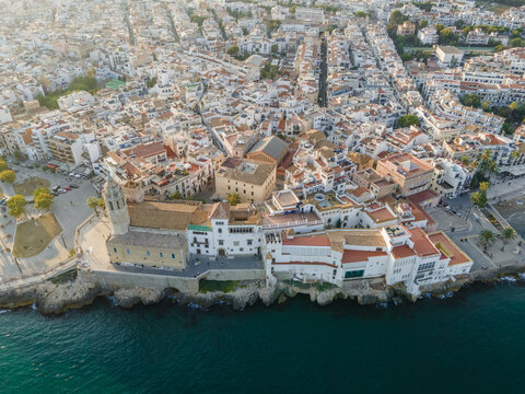 Aerial view of the Church of Sant Bartomeu i Santa Tecla and the historic coastal buildings overlooking the Mediterranean Sea in Sitges, Catalonia, Spain.