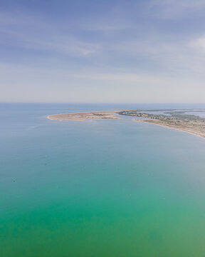Aerial view of the Ebro Delta featuring its sandy coastline and turquoise Mediterranean waters under a clear sky Catalonia, Spain.