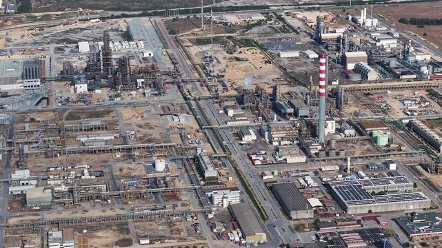 Machines hum and workers move diligently at the oil refinery, where crude oil transforms into valuable fuel. This industrial site highlights essential energy production processes at play.