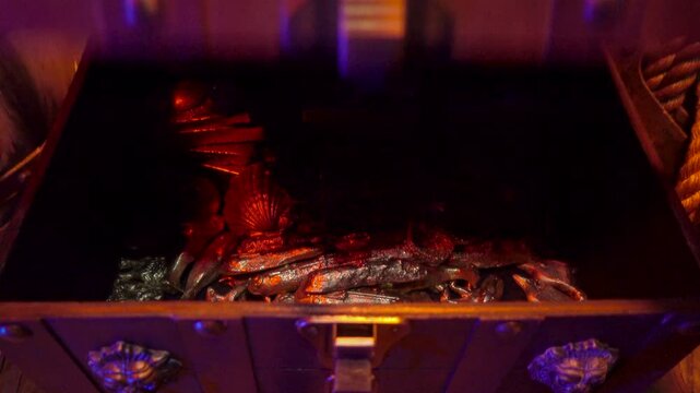 Treasure chest filled with gold ingots and other valuables in closed.