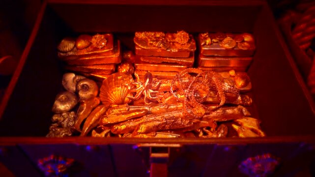 Treasure chest is opened revealing gold ingots and valuables.