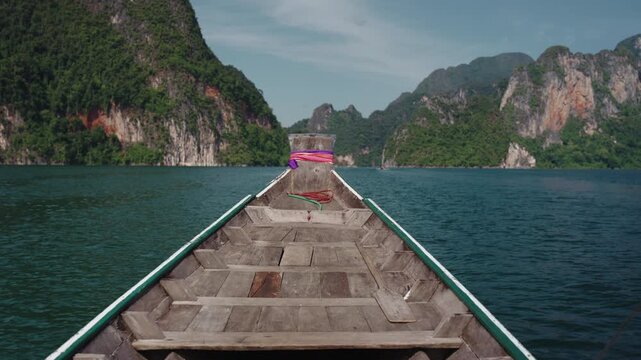 Cinematic POV from Traditional Longtail Boat Prow Sailing Towards Iconic Limestone Karsts, Emerald Green Water of Khao Sok National Park, 4k Video