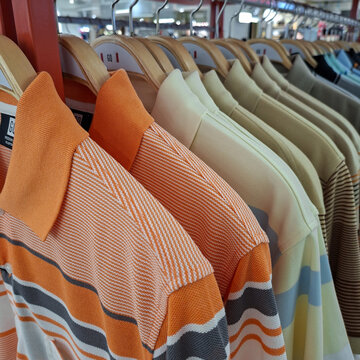 GQ mens polo shirts with various colors hanging on wooden hangers on May 9, 2026 in Bangkok, Thailand.