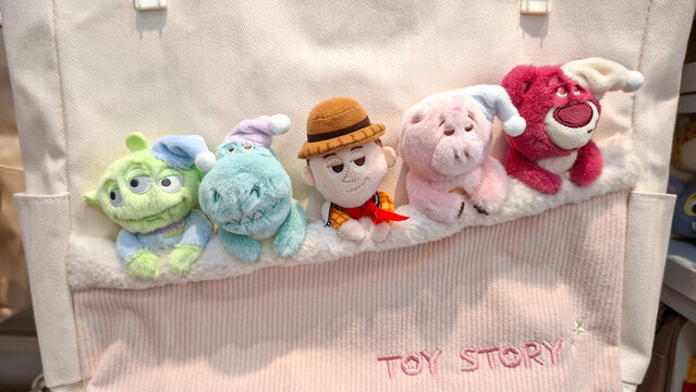 ​White canvas tote bag featuring embroidered Toy Story characters: Alien, Rex, Woody, Hamm and Lotso in sleeping pajamas theme on May 6, 2026 in Bangkok, Thailand.