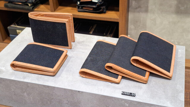 Collection of Piger Works's premium handmade indigo denim and brown leather wallets displayed on concrete pedestal on May 8, 2026 in Bangkok, Thailand.