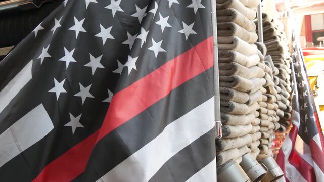 Red thin line black american flag on firefighter truck. Hose of firetruck and fire fighters symbol in New York, United States. 911 remembrance, fire department engine vehicle. September 11 Patriot Day