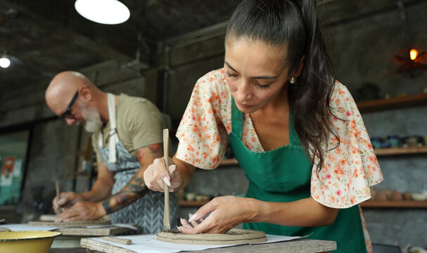 A happy couple makes ceramic plates in a workshop