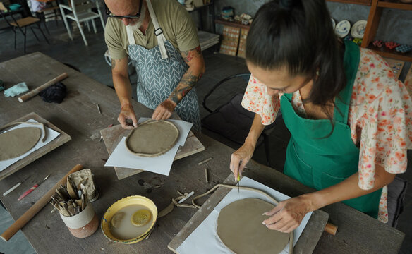 A happy couple makes ceramic plates in a workshop