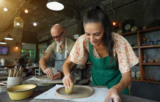 A happy couple makes ceramic plates in a workshop