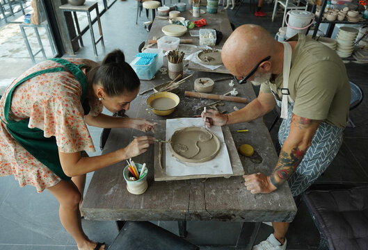 A happy couple makes ceramic plates in a workshop
