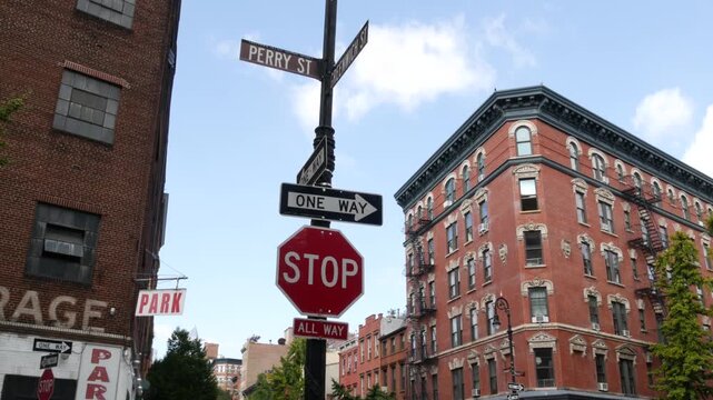 New York City Greenwich and Perry street corner, sign in Manhattan West Village, United States. Urban road sign, traffic sign in NYC. Red brick classic building architecture. Lantern, One way and Stop
