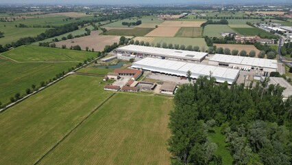 Naklejka premium Agricultural Enterprise in Aerial View: An extensive agricultural enterprise stands amidst vast fields and verdant landscapes.