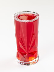 Vibrant red berry drink in a faceted glass tumbler, isolated on a clean white background. © Andrei Starostin