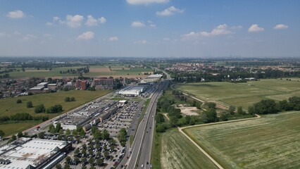 Obraz premium Urban Sprawl Over Countryside: An aerial view captures the relentless spread of suburban development encroaching upon vast tracts of agricultural land and green fields.