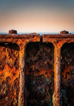 Severe corrosion visible on thick industrial steel infrastructure supporting maritime operations near the saltwater environment, decay, metallic, port