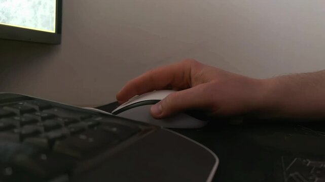 Hand using computer mouse at desk, modern workspace scene, technology and productivity concept.