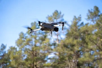 Fototapeten Hubschrauber drone flying against a blue summer sky.  © alexander