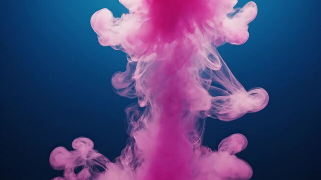 Pink ink cloud exploding against deep blue backdrop abstract concept